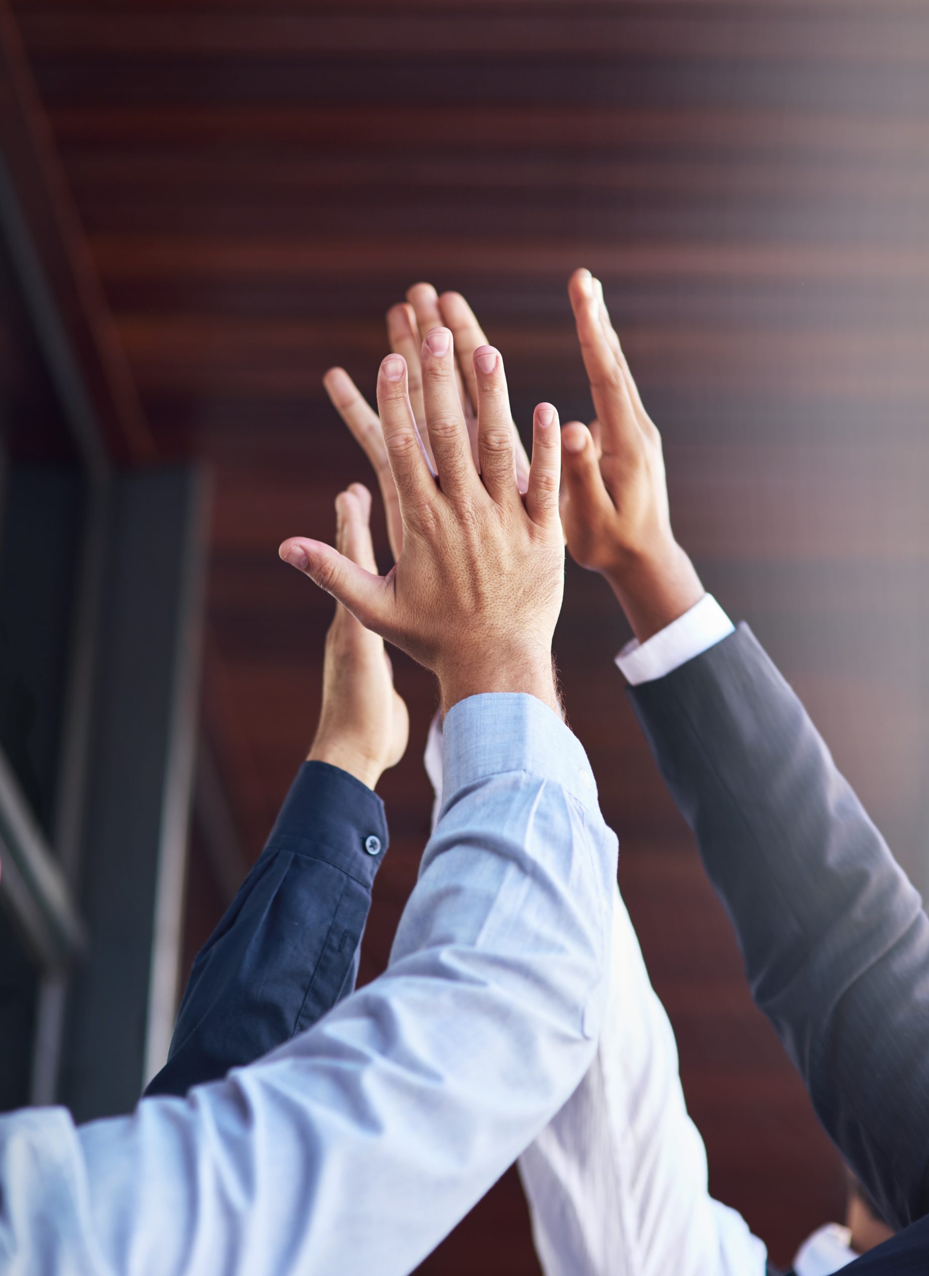 Cropped shot of a group of unidentifiable businesspeople high fiving in the office